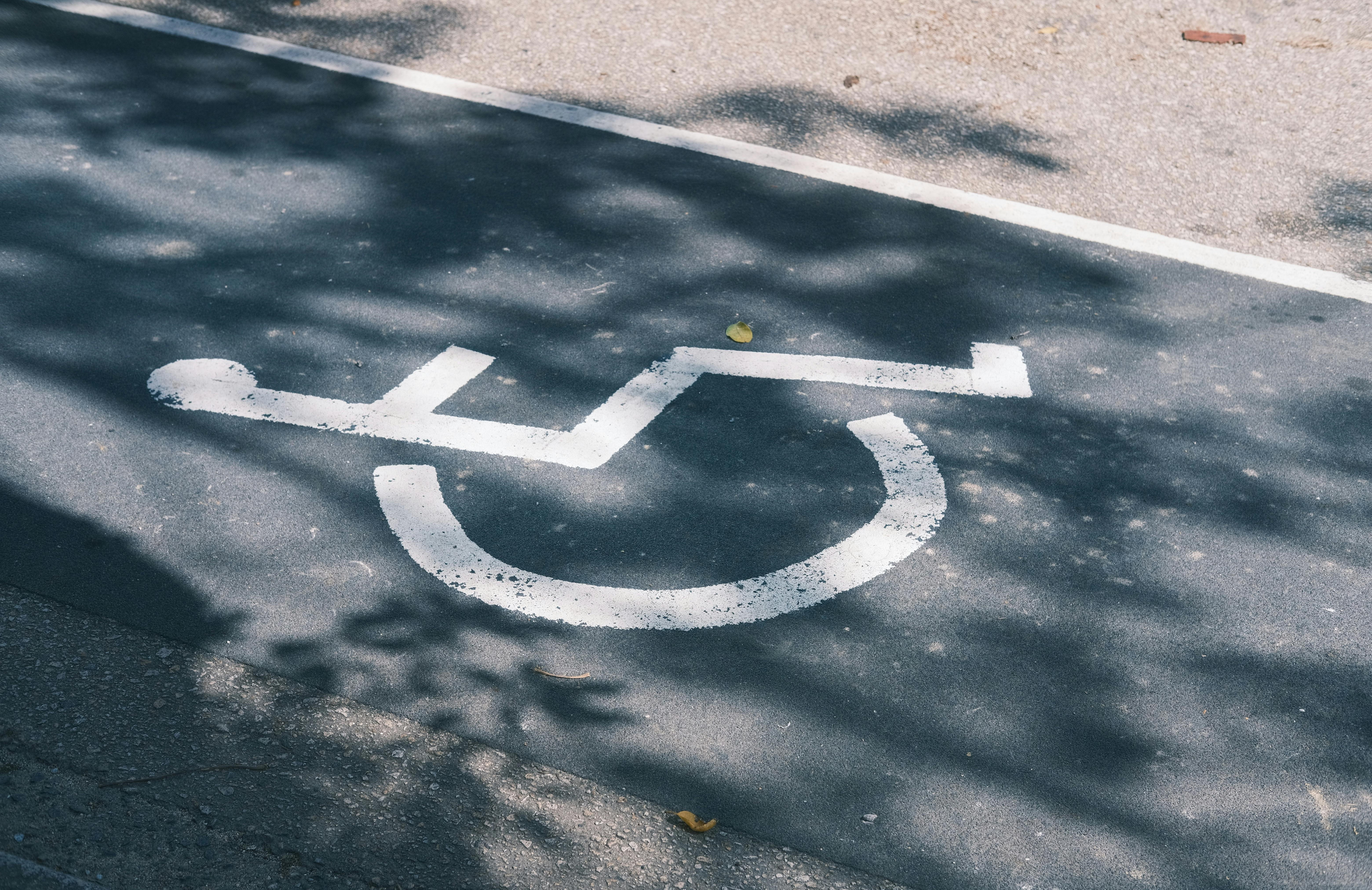 Wheelchair accessibility marking on
pavement highlighting the need for ADA-compliant medical transportation.